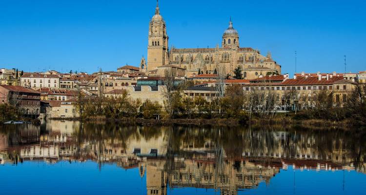 La cathédrale de Salamanque et l'horizon historique parfaitement reflétés dans la rivière calme.