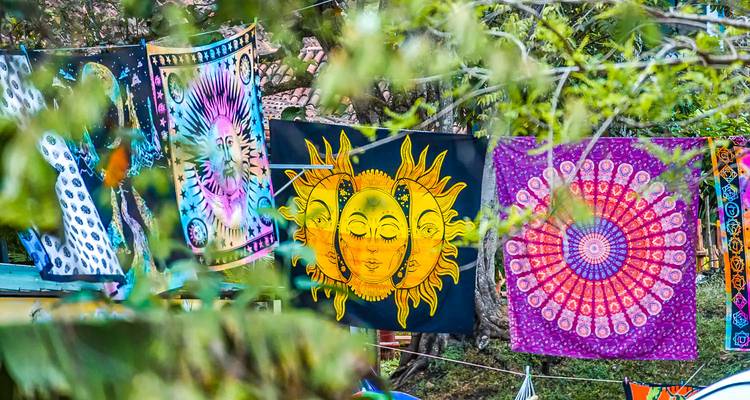 Kleurrijke wandtapijten die buiten hangen met bomen op de achtergrond.