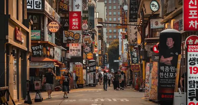Rue animée de Séoul avec de nombreuses enseignes et des gens qui marchent.
