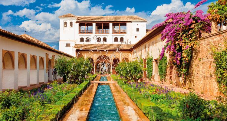 Een tuinbinnenplaats met een waterelement en bloemen.