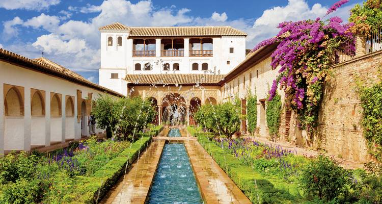 Schöner Garten vor einem historischen Gebäude mit leuchtenden Blumen.