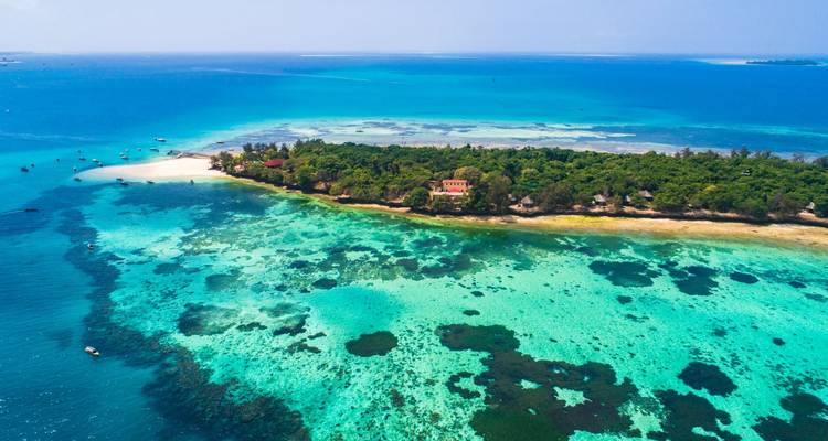 Luftaufnahme einer tropischen Insel mit klarem blauem Wasser.