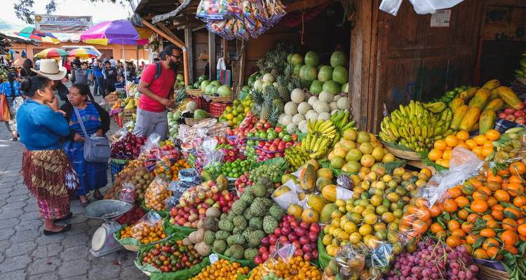 Marché de fruits coloré avec des vendeurs et des clients.