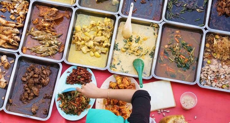 An array of colorful traditional dishes being served outdoors.
