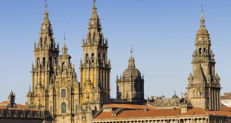 Cathédrale ornée avec plusieurs tours dans un paysage urbain.