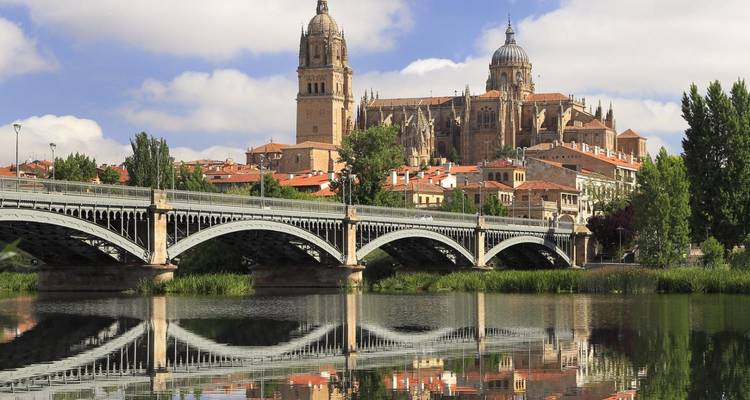 Cathédrale et pont se reflétant sur l'eau calme de la rivière.