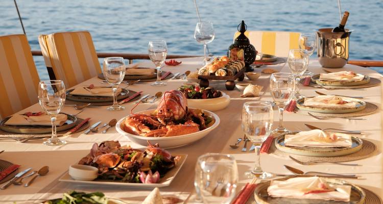 Configuration de repas élaborée avec fruits de mer et boissons sur une table.