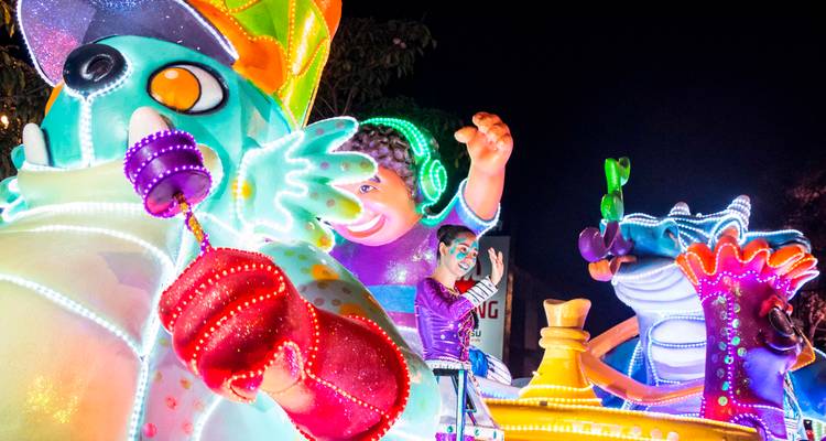 Colorful parade float with illuminated characters at night.