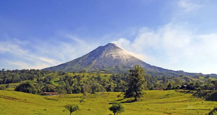 Majestic volcano with a clear blue sky and lush landscape.
