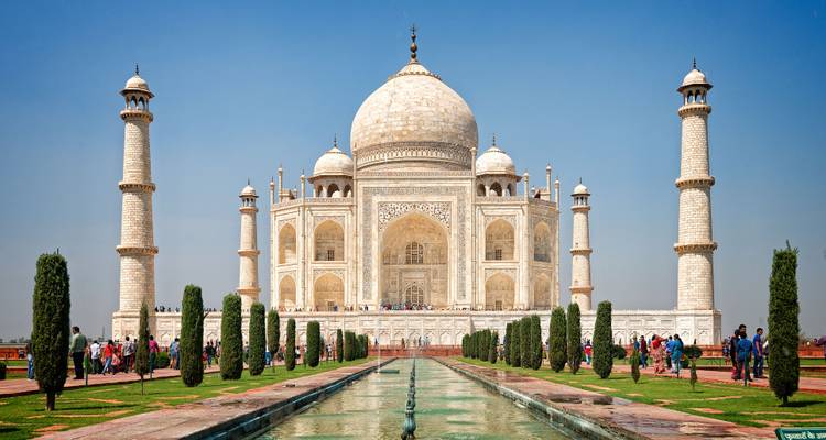 De iconische witte marmeren Taj Mahal met bezoekers die er een bezoek brengen.