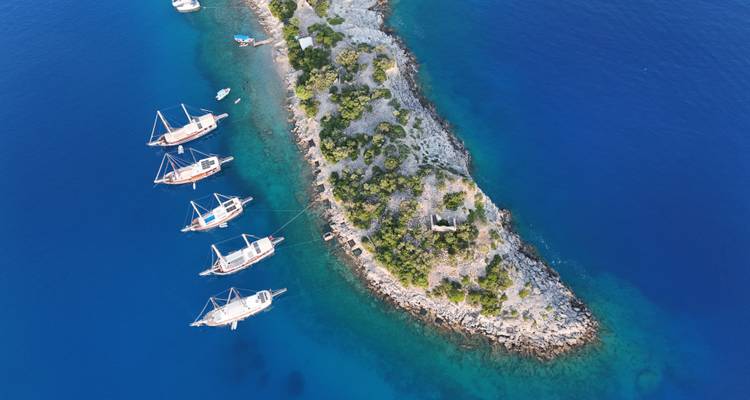 Vue aérienne de bateaux ancrés le long d'une île étroite.