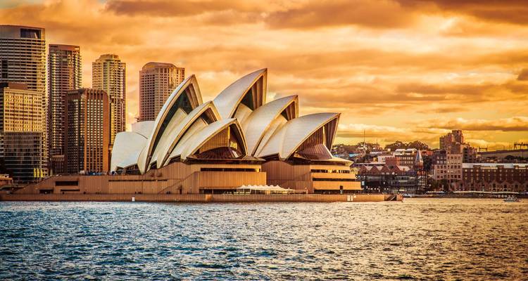 Opéra de Sydney avec horizon de la ville et coucher de soleil dramatique.