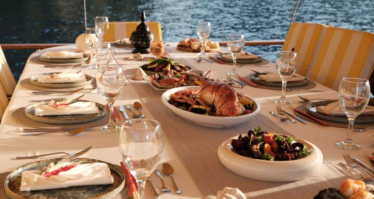 Luxurious dining setup with diverse dishes on a boat.