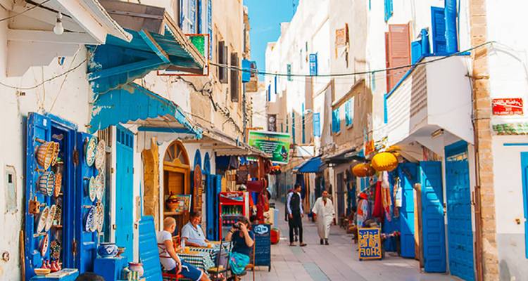 Colorful bustling street market with people shopping.