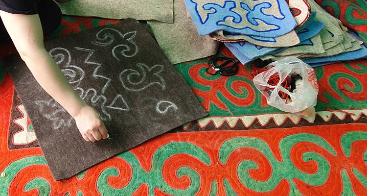 Persona trabajando en patrones de tela coloridos.