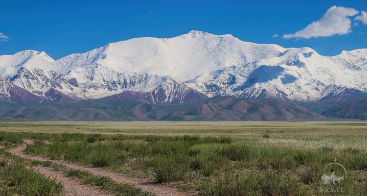 De vastes plaines avec en toile de fond des montagnes enneigées.