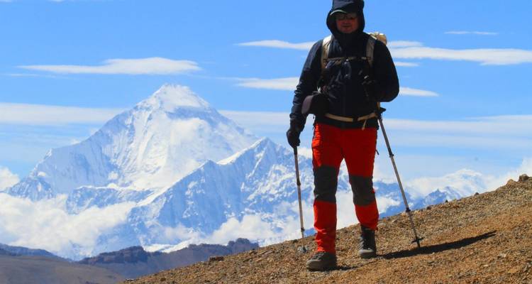 Excursionista con montañas cubiertas de nieve en el fondo.