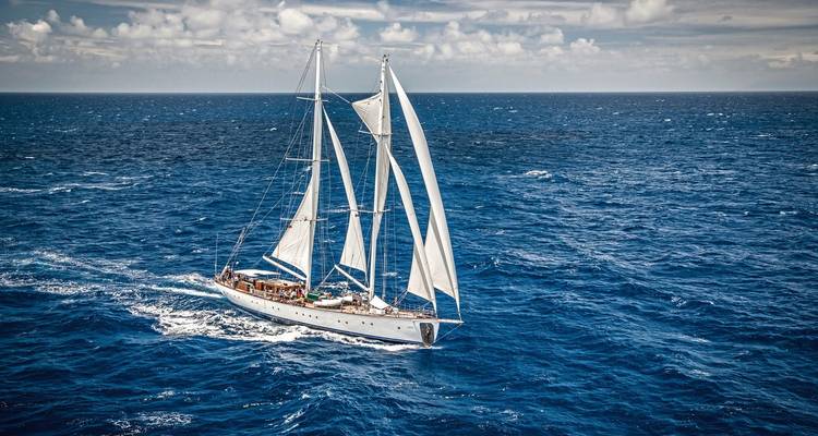 Sailing yacht on open blue ocean.