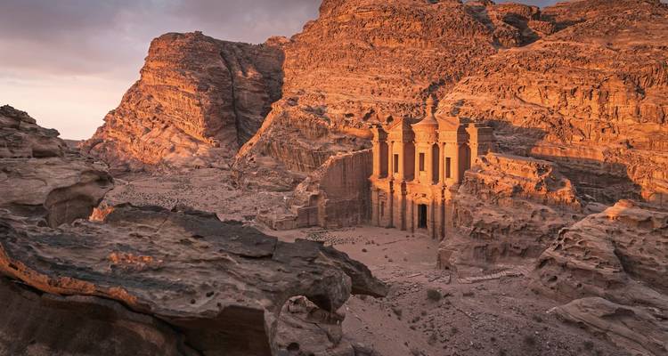Monastery in Petra, Jordan, surrounded by reddish rock formations.