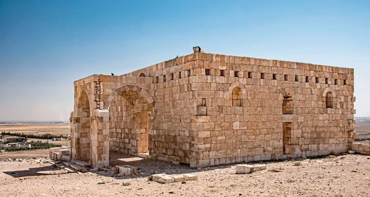 Stone structure on a hilltop in a barren landscape.