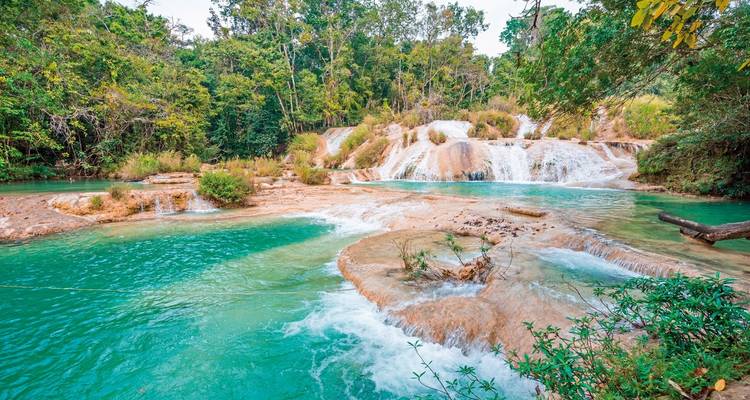 Cascading waterfalls with turquoise water surrounded by jungle.