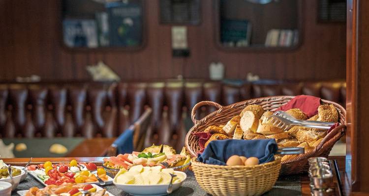 Buffet setup with bread, fruits, and cheese.