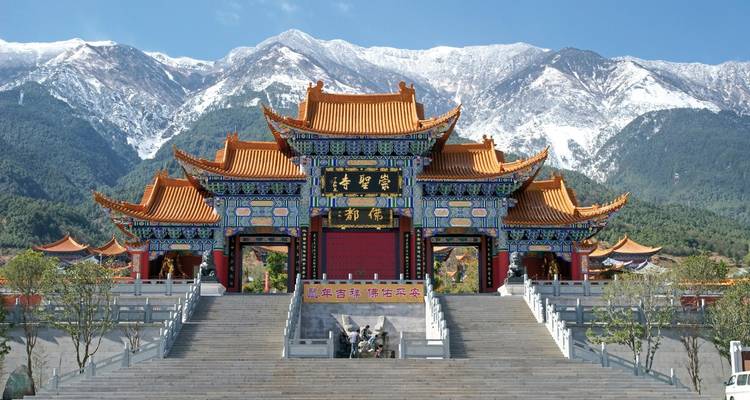 Un temple chinois traditionnel avec des montagnes enneigées en arrière-plan
