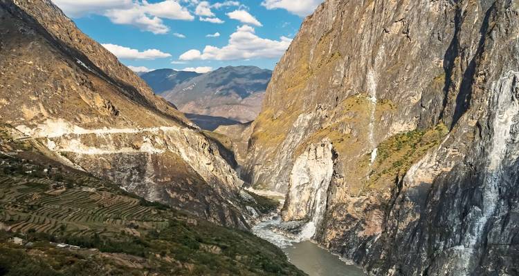 Vue panoramique des Gorges du Saut du Tigre avec une rivière au fond et des champs en terrasses.