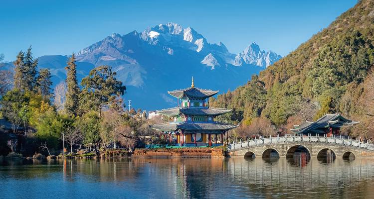 Pagode et pont traditionnels avec la montagne enneigée du Dragon de Jade en arrière-plan.