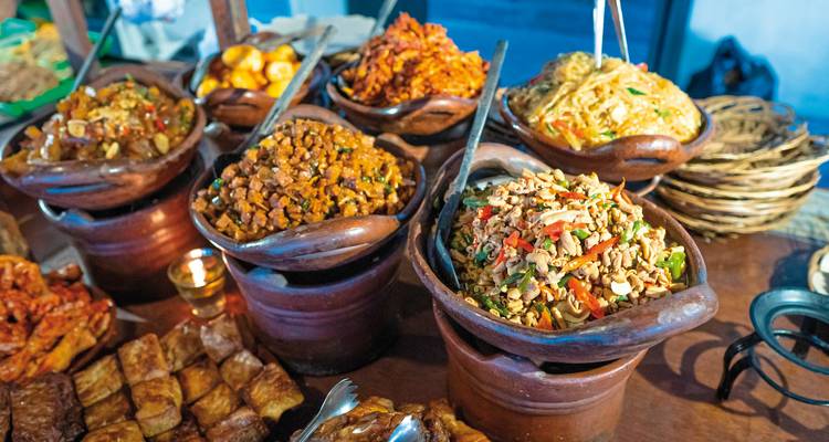 Variété de plats traditionnels indonésiens dans des pots en argile.