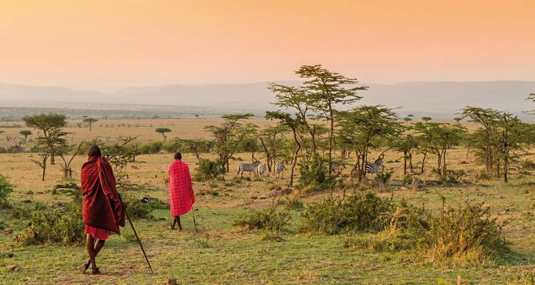 Deux individus en tenue traditionnelle surveillant une savane.