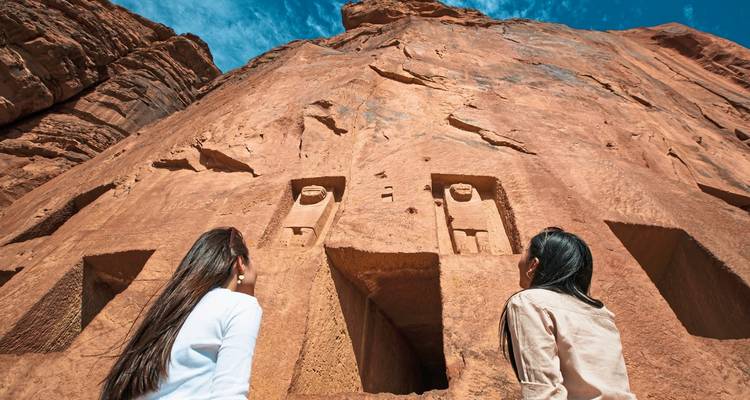 Deux femmes regardant de l'art rupestre ancien dans le désert.