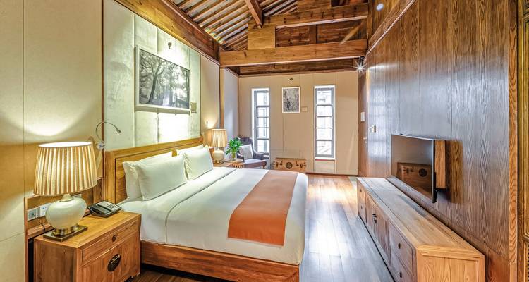 Chambre d'hôtel luxueuse avec intérieurs en bois et grand lit.