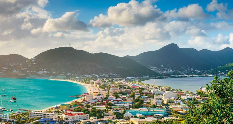 Vue aérienne d'une ville côtière avec plages et montagnes.