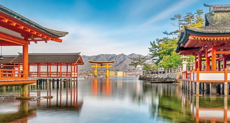 Itsukushima-Schrein schwimmendes Tor mit Wasserspiegelung und Bergen.