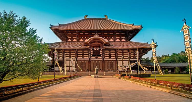 Vue extérieure d'un temple japonais traditionnel avec un ciel bleu dégagé.