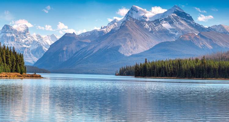 Pristine lake with snow-capped mountains reflecting in the water.