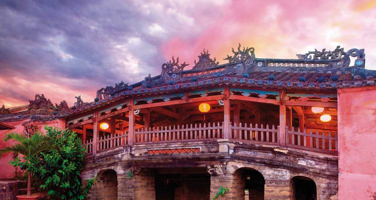 Alte Brücke mit Laternen in der Dämmerung.