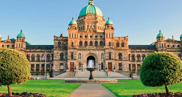 Verziertes Gebäude mit grünen Kuppeln und Brunnen davor.