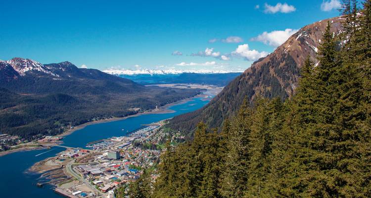 Luftaufnahme einer Küstenstadt mit umliegenden Bergen.