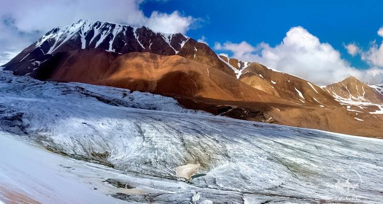 Vue sur le glacier avec premier plan rocheux.