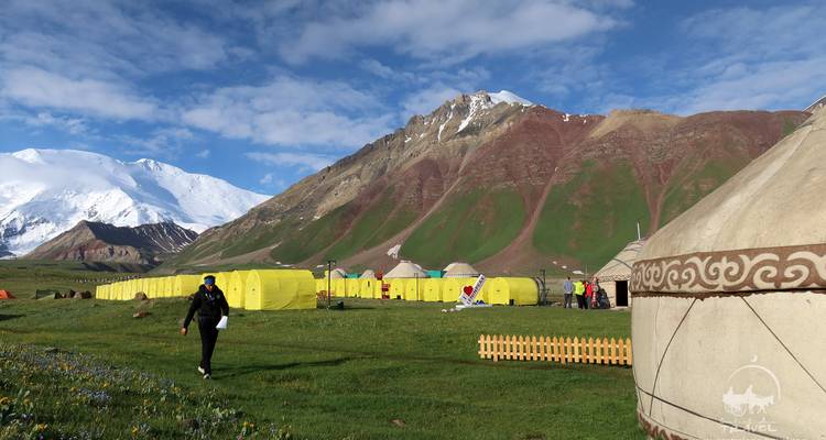 Campement de yourtes avec toile de fond montagnarde.