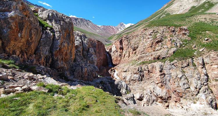 Gorge rocheuse avec une cascade qui coule à travers les montagnes.