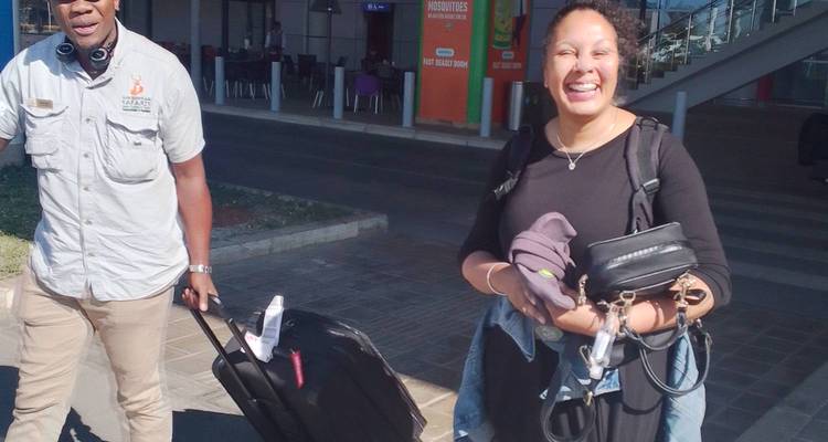 Deux personnes avec des bagages devant un bâtiment.