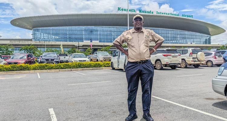 Personne debout devant l'aéroport international Kenneth Kaunda.