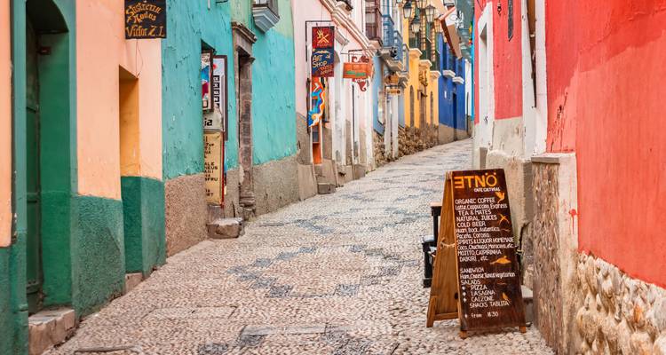 Colorful street scene with textured cobblestone and vibrant facades.
