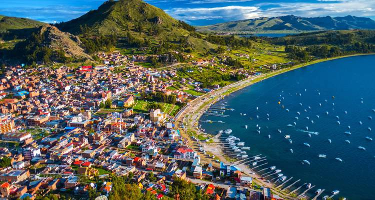 Aerial view of a coastal town with colorful buildings and a bay filled with boats.