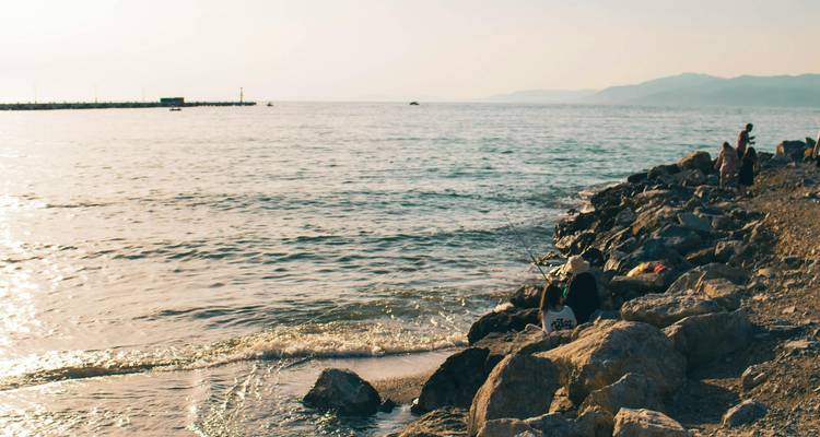 Des gens qui pêchent le long de la côte rocheuse.