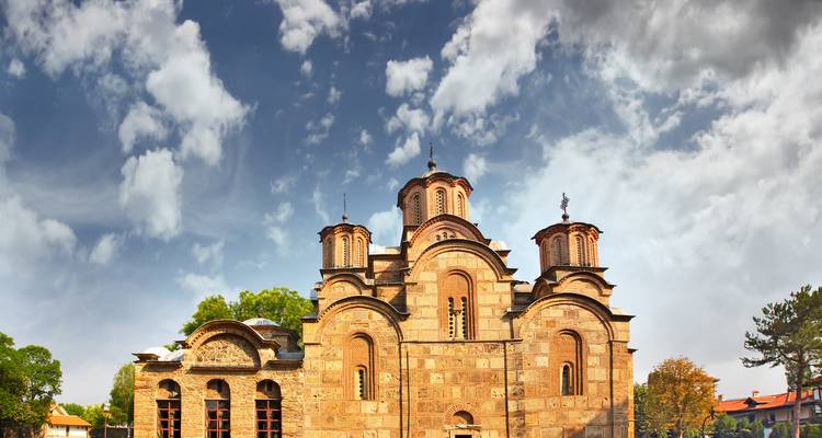 Église historique avec plusieurs dômes sous un ciel partiellement nuageux.