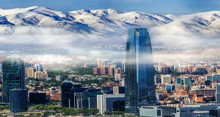 Horizon urbain avec des montagnes enneigées en arrière-plan.